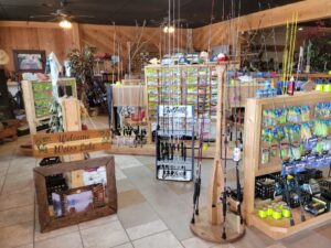 bt 2 Fishing supply store interior with rods, reels, tackle, and a "Welcome Weiss Lake" sign on display.